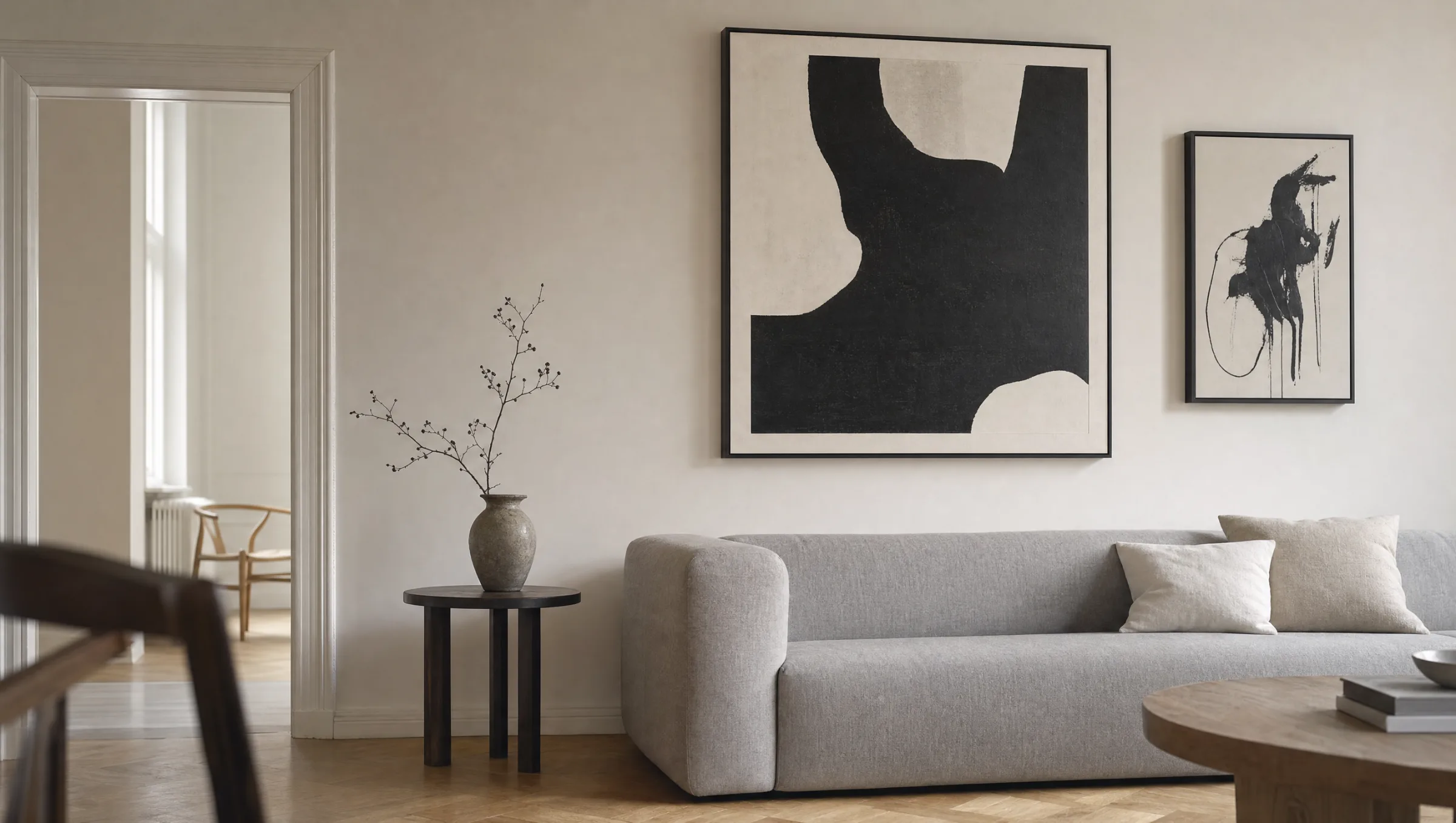 Wohnzimmerwand mit abstrakten Schwarzweiß-Bildern über einem hellen Sofa